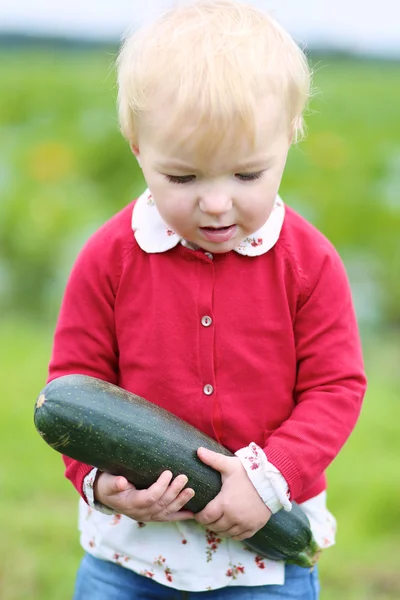 Flicka som tunga mogen zucchini — Stockfoto