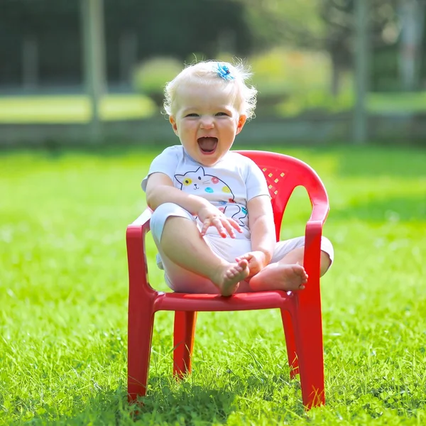 Baby flicka skratta och sitter på stol — Stockfoto