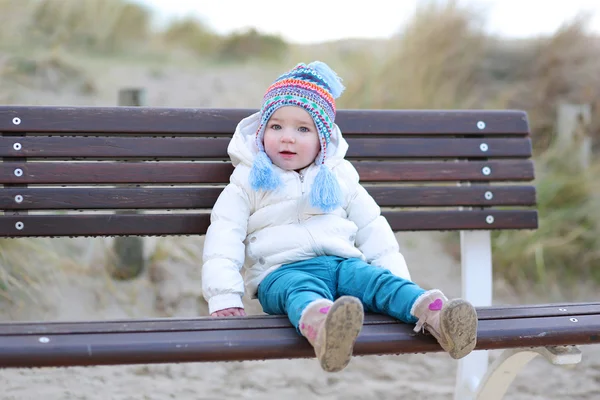 Girl on the bench next to sandy dunes — Stock Photo, Image