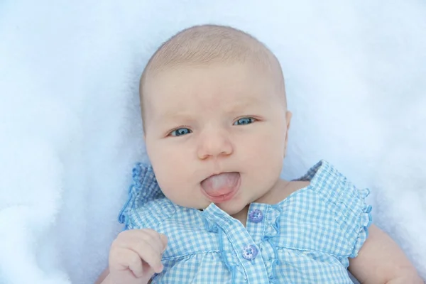 Baby girl with her tongue out of her mouth — Stock Photo, Image