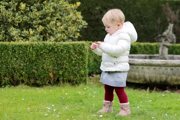 Ragazza raccogliendo fiori in primavera in un bellissimo parco — Foto Stock