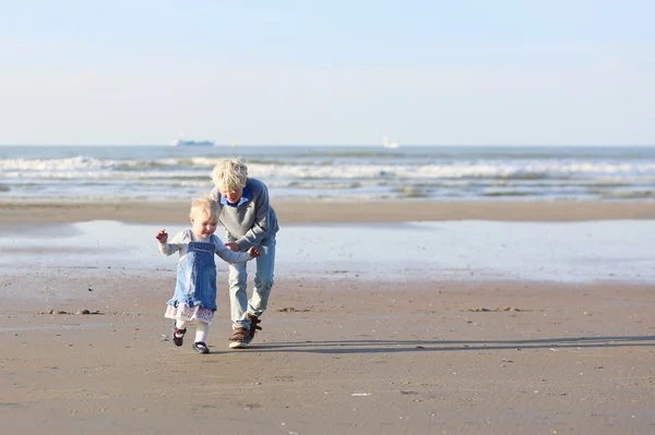 Bror och syster kör på stranden — Stockfoto