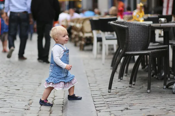 Mädchen steht neben Stuhl eines Straßencafés — Stockfoto