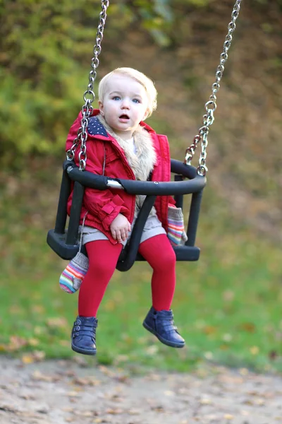 Meisje van de baby plezier op een schommel — Stockfoto