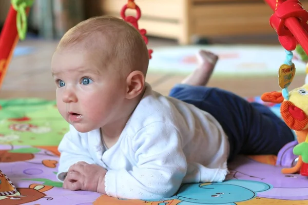 Baby girl laying on play mat — Stock Photo, Image