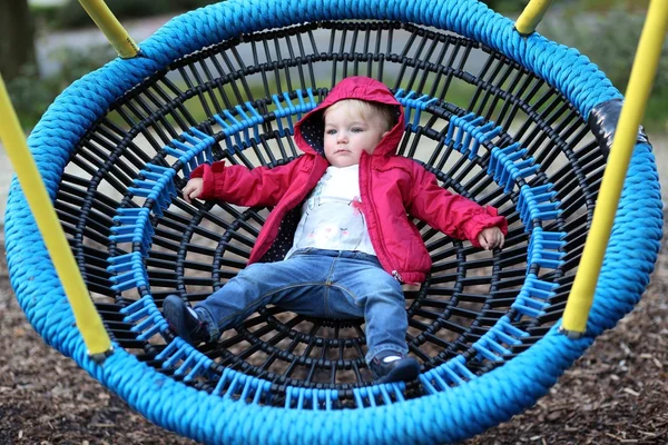 Baby flicka avkopplande på en gunga netto — Stockfoto