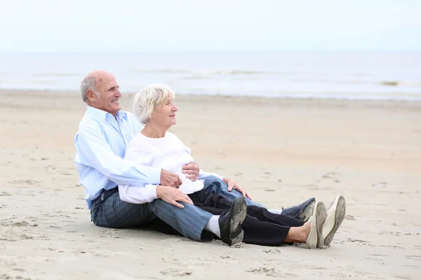Couple sitting  on sandy peaceful beach — Stock Photo, Image