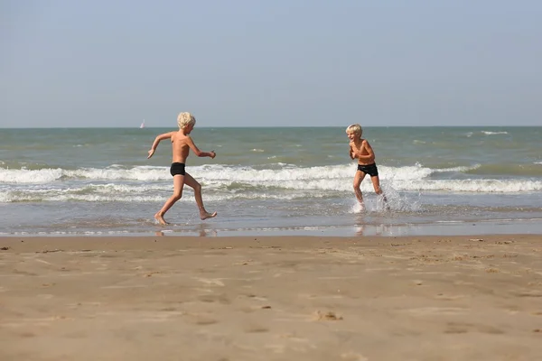 実行しているビーチで双子の兄弟 — ストック写真