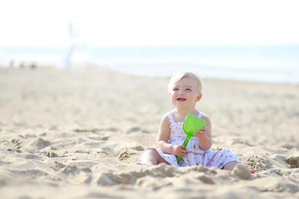 Bambina seduta sulla riva del mare — Foto Stock