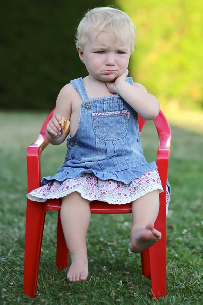 Baby flicka sitter på stol utomhus — Stockfoto