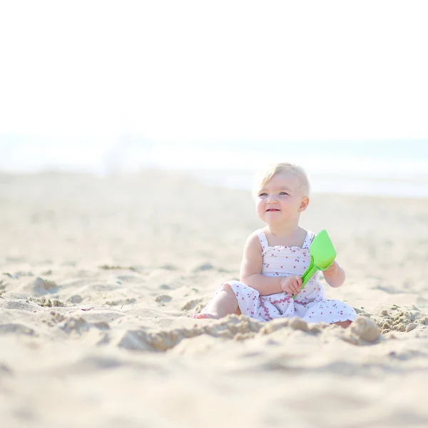 Baby girl sitting on beach — Stock Photo, Image