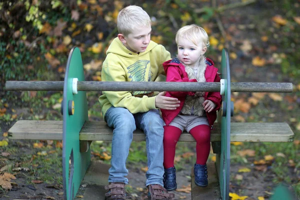 Fratello con sorella divertirsi nel parco giochi — Foto Stock