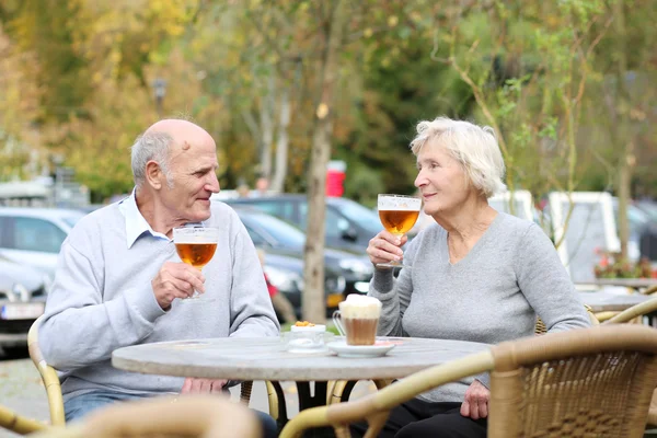 Casal de idosos desfrutando de um copo de cerveja gelada — Fotografia de Stock