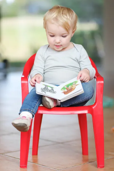 Baby girl reading children book about animals — Stock Photo, Image