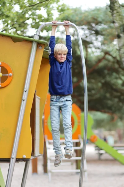 Jongen plezier op speelplaats in het park — Stockfoto