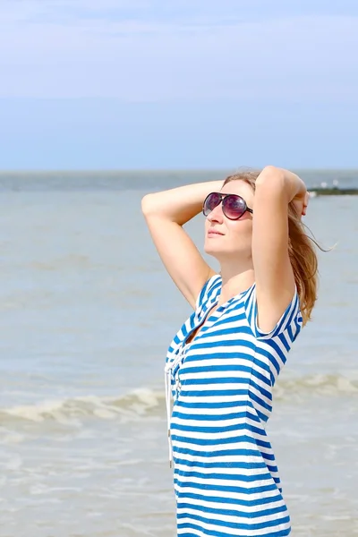 Kvinna som njuter av solen på stranden — Stockfoto