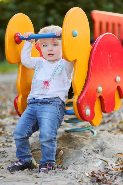 Girl riding on the spring horse — Stock Photo, Image