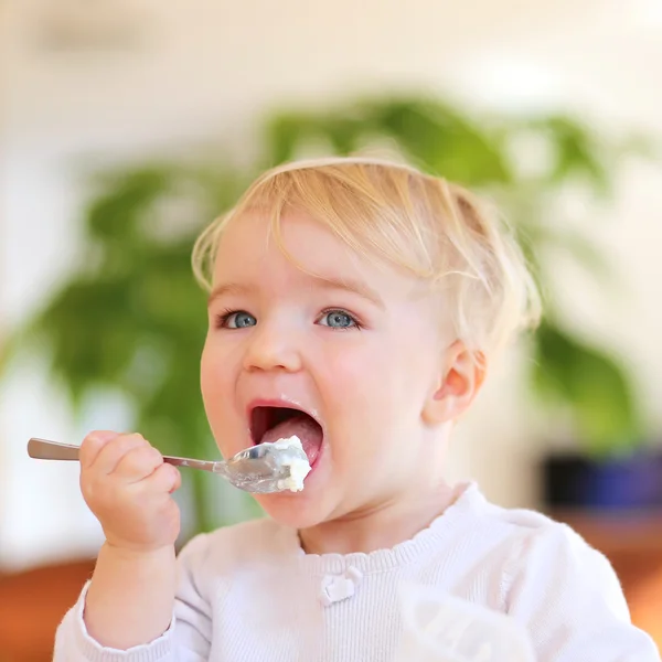 Menina comendo iogurte delicioso — Fotografia de Stock