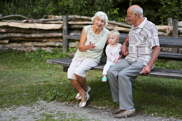 Abuelo y abuela con el bebé en un banco —  Fotos de Stock