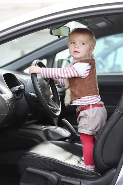 Babymeisje binnenkant van de auto op bestuurdersstoel — Stockfoto