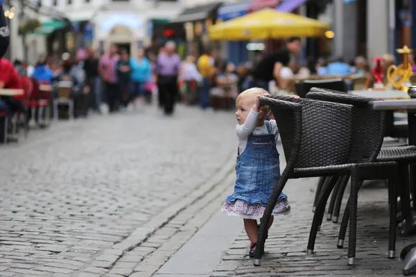 Κοριτσάκι που στέκεται δίπλα στην καρέκλα του δρόμου café — Φωτογραφία Αρχείου