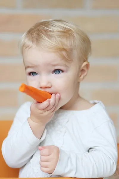 Baby-Mädchen beißt auf köstliche frische rohe Karotte — Stockfoto