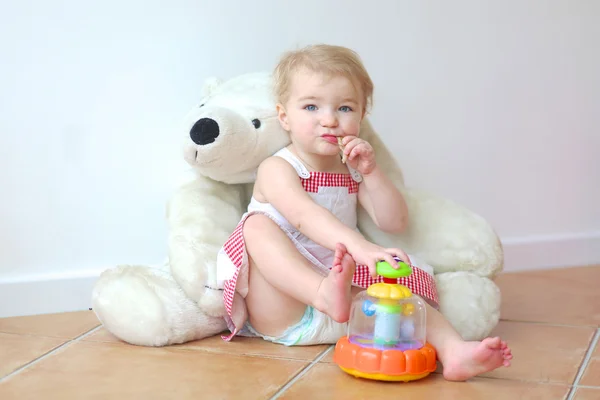 Menina sentada em um grande urso de pelúcia branco — Fotografia de Stock