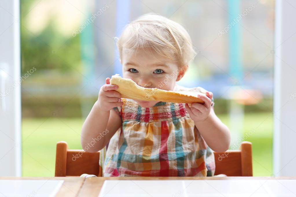 Girl eating tasty bread with butter