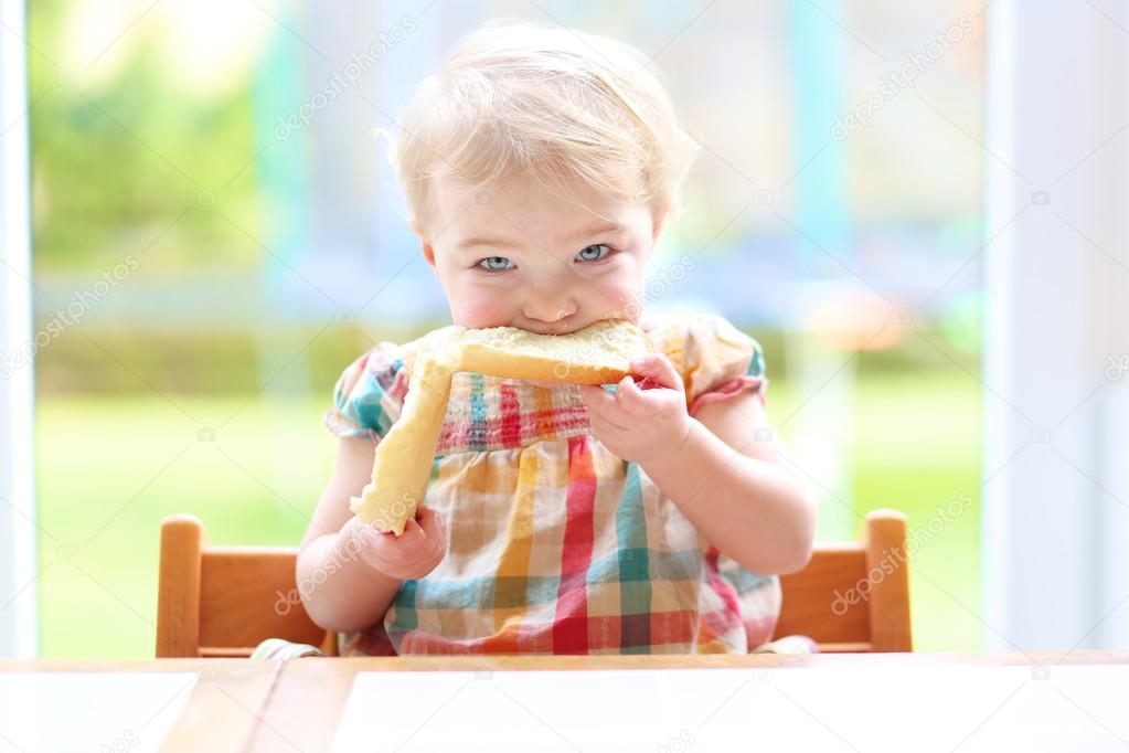 Girl eating tasty bread with butter