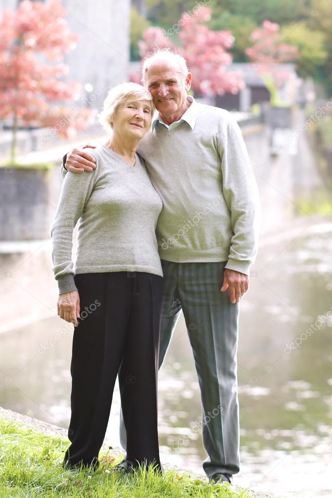 Smiling seniors at the shore of the river