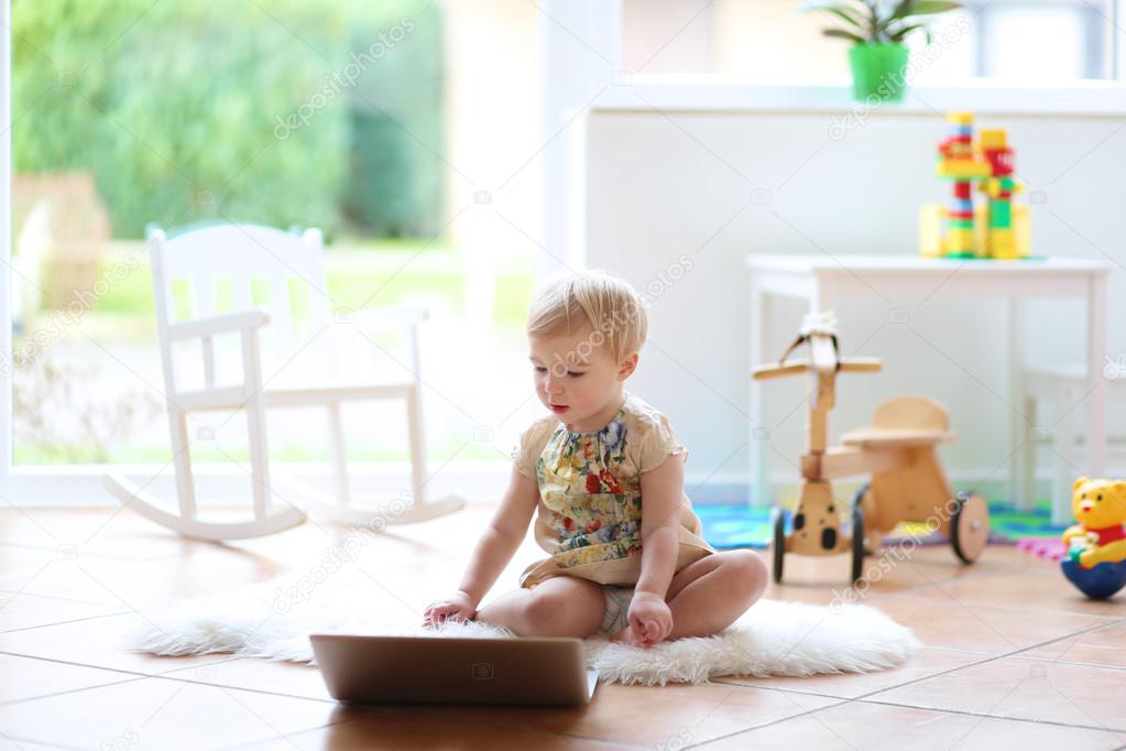 Girl playing with notebook indoors