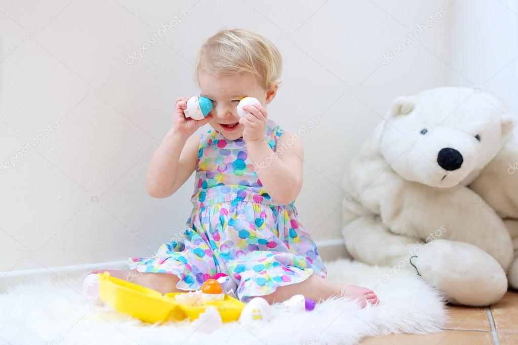 Girl playing indoors sorting colorful plastic eggs