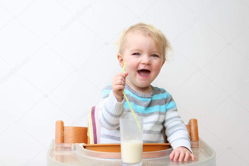 Girl drinking milk from the glass with straw