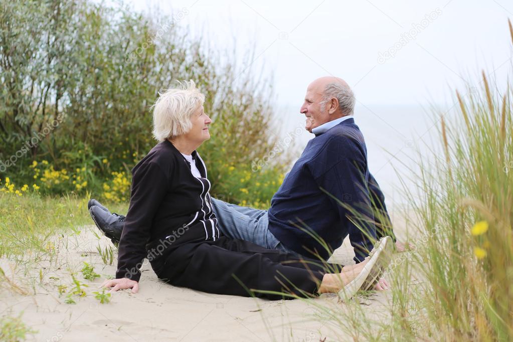 Senior couple sitting in the dunes