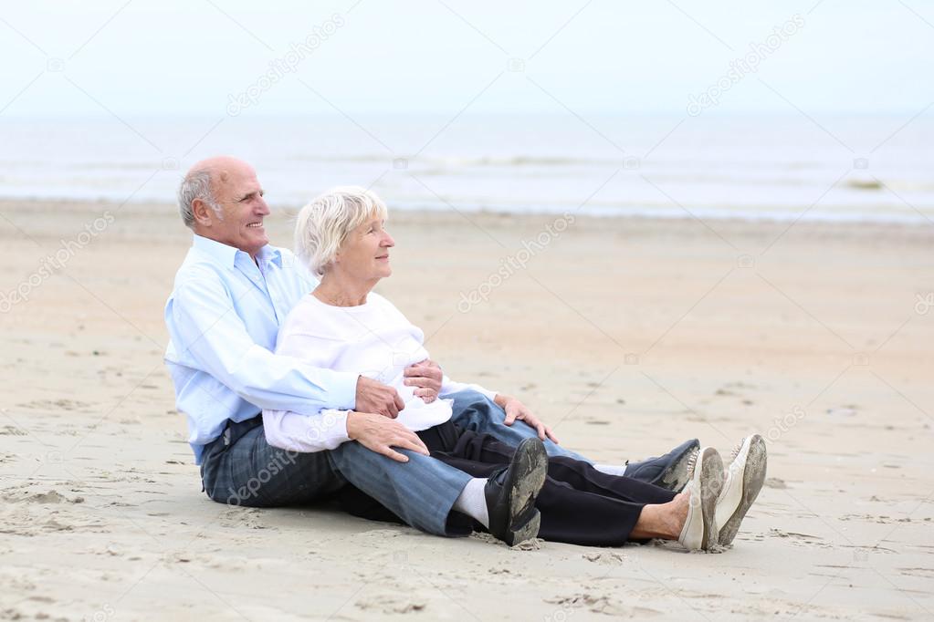Couple sitting  on sandy peaceful beach