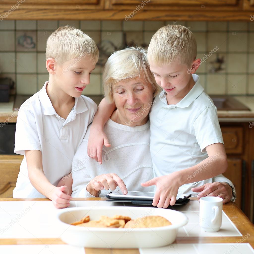 Brothers teaching grandmother to play on tablet pc