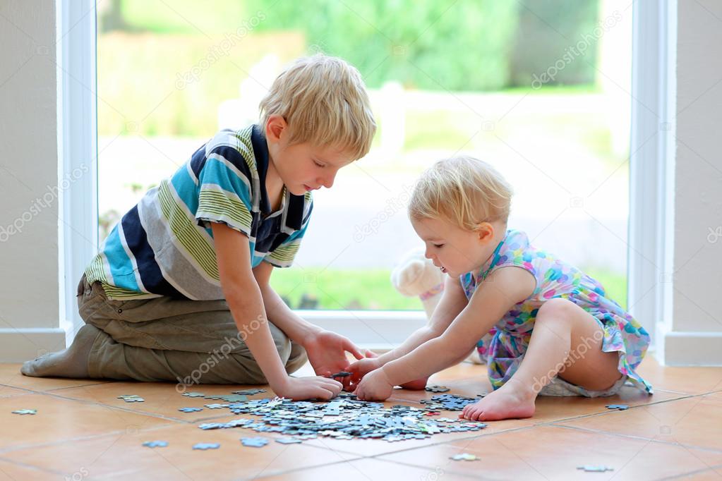 Girl playing puzzles with her teenager brother