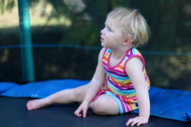 Kızın rahatlatıcı arka bahçe trambolin üzerinde