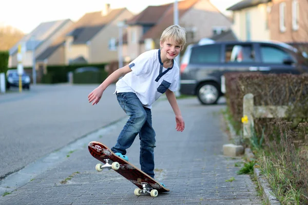 Adolescente niño aprendiendo a equilibrarse en el monopatín — Foto de Stock