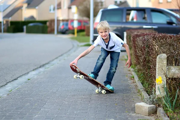 Niño aprendiendo a equilibrarse en el monopatín — Foto de Stock