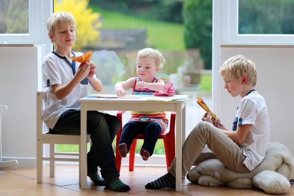 Broers met zus maken papier vliegtuigen — Stockfoto