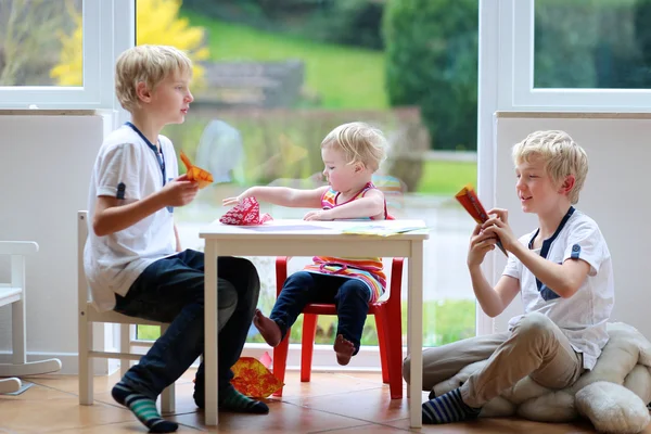 Hermanos con hermana haciendo planos de papel — Foto de Stock