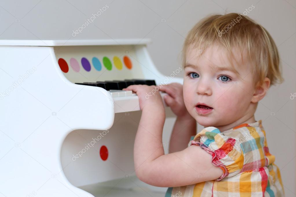 Girl learning to play on piano toy