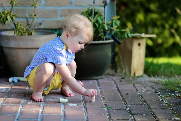 Meisje zit op terras tekenen met krijt — Stockfoto