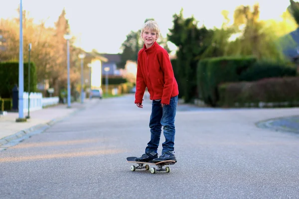Мальчик учится балансировать на скейтборде, играя на улице — стоковое фото