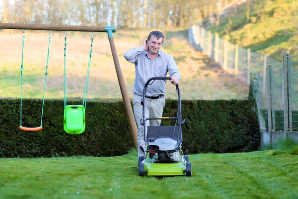 Man mowing the lawn in the backyard — Stock Photo, Image