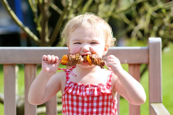 Ragazza mangiare carne fatta sul barbecue — Foto Stock