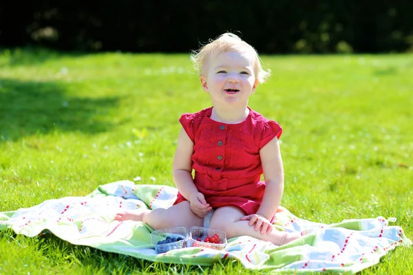 Mutlu bebek kız bahçede çilek yeme — Stok fotoğraf