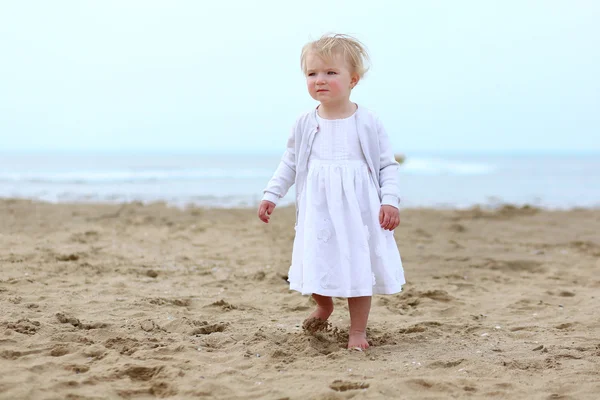 Vacker flicka i vit klänning promenader längs stranden — Stockfoto