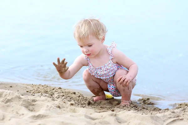 Szczęśliwego malucha dziewczyna gra na plaży — Zdjęcie stockowe